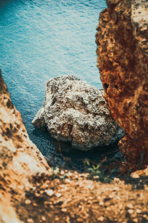 a rock formation next to water with an open mouth