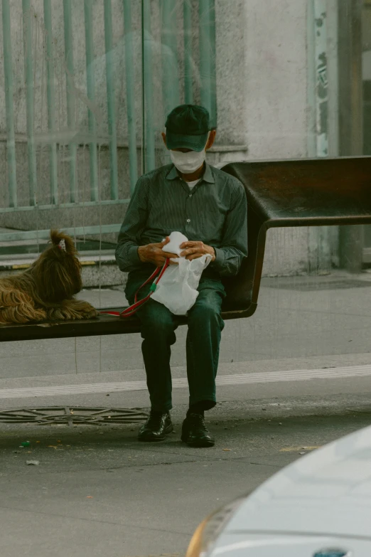 a man sitting on a bench in front of a bear