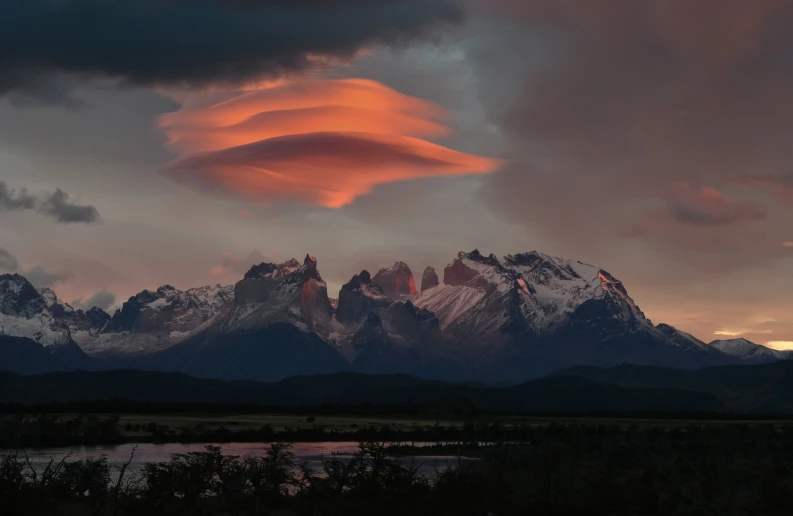 there is a fish shaped cloud over a mountain range