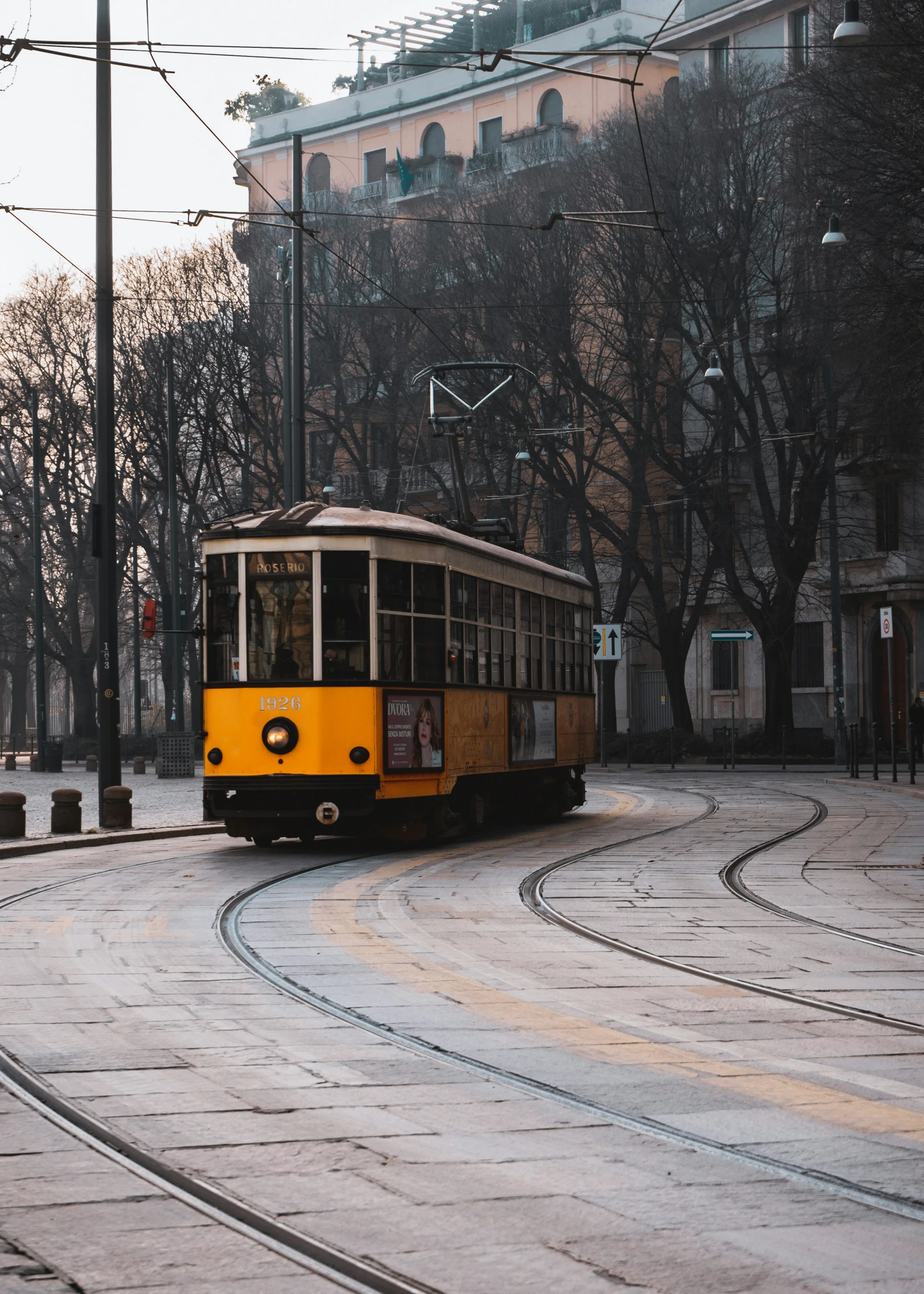 a trolley rides down the tracks in an urban area