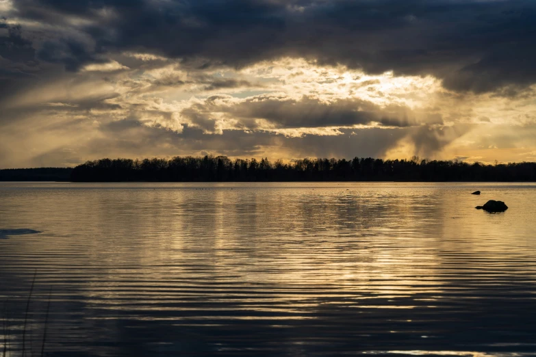 the sunset is shining on a beautiful lake