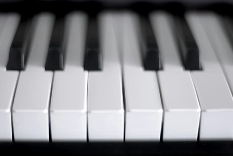 close up of a white piano with black keys