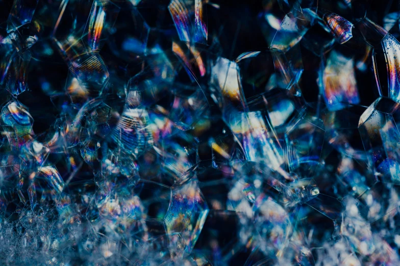 a large amount of shattered glass with blue and green reflections