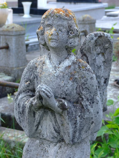 an old statue is shown in a cemetery