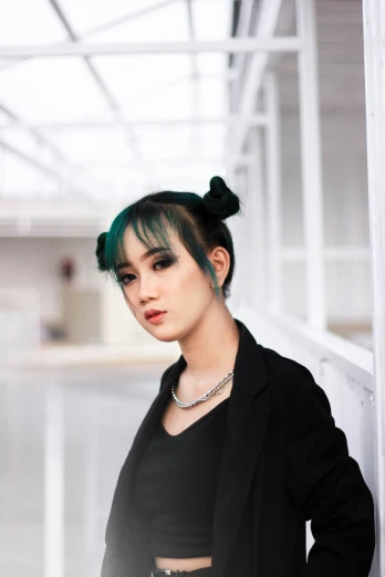 a woman with green hair is leaning against a wall