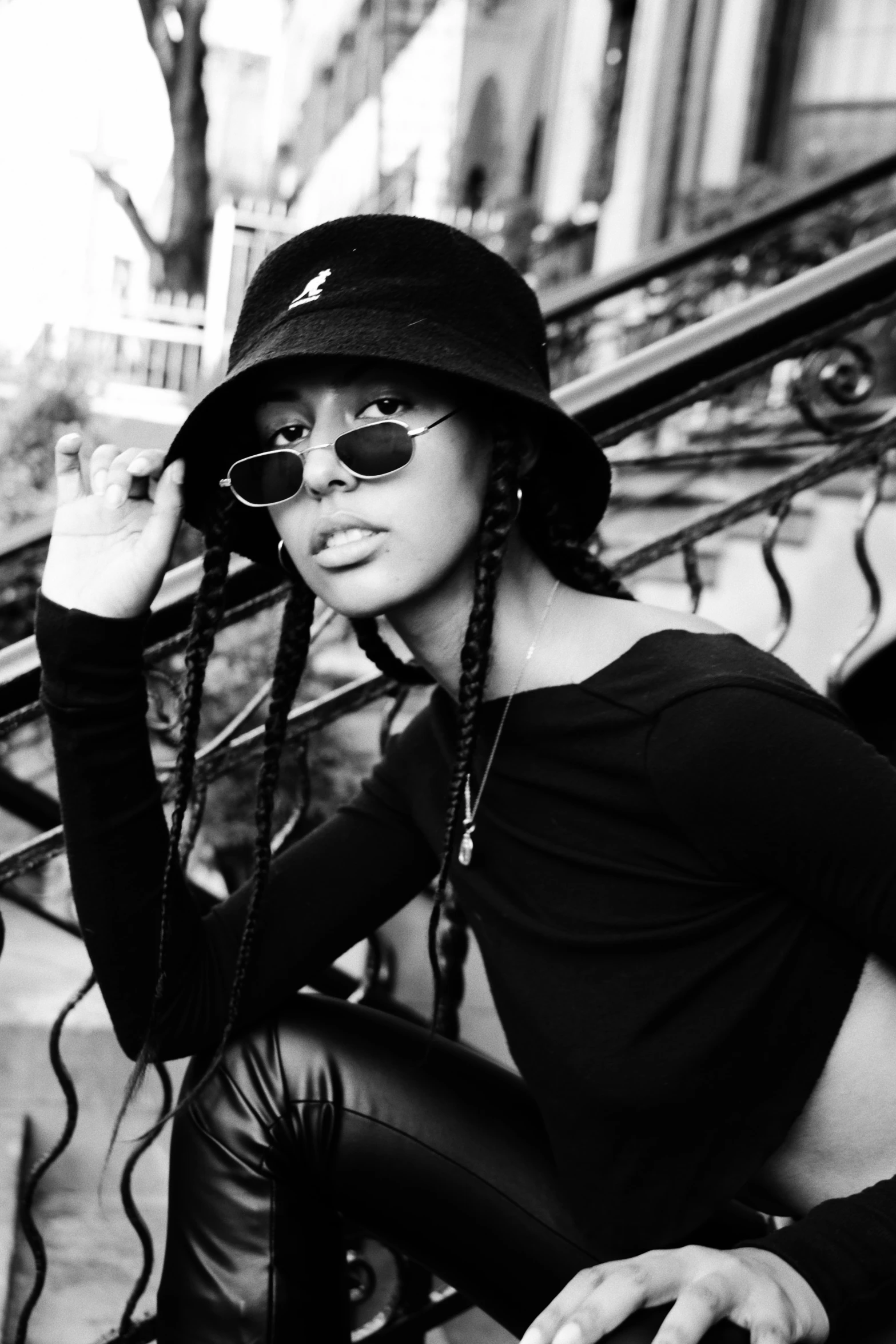 a woman with ids and a hat sitting on some stairs