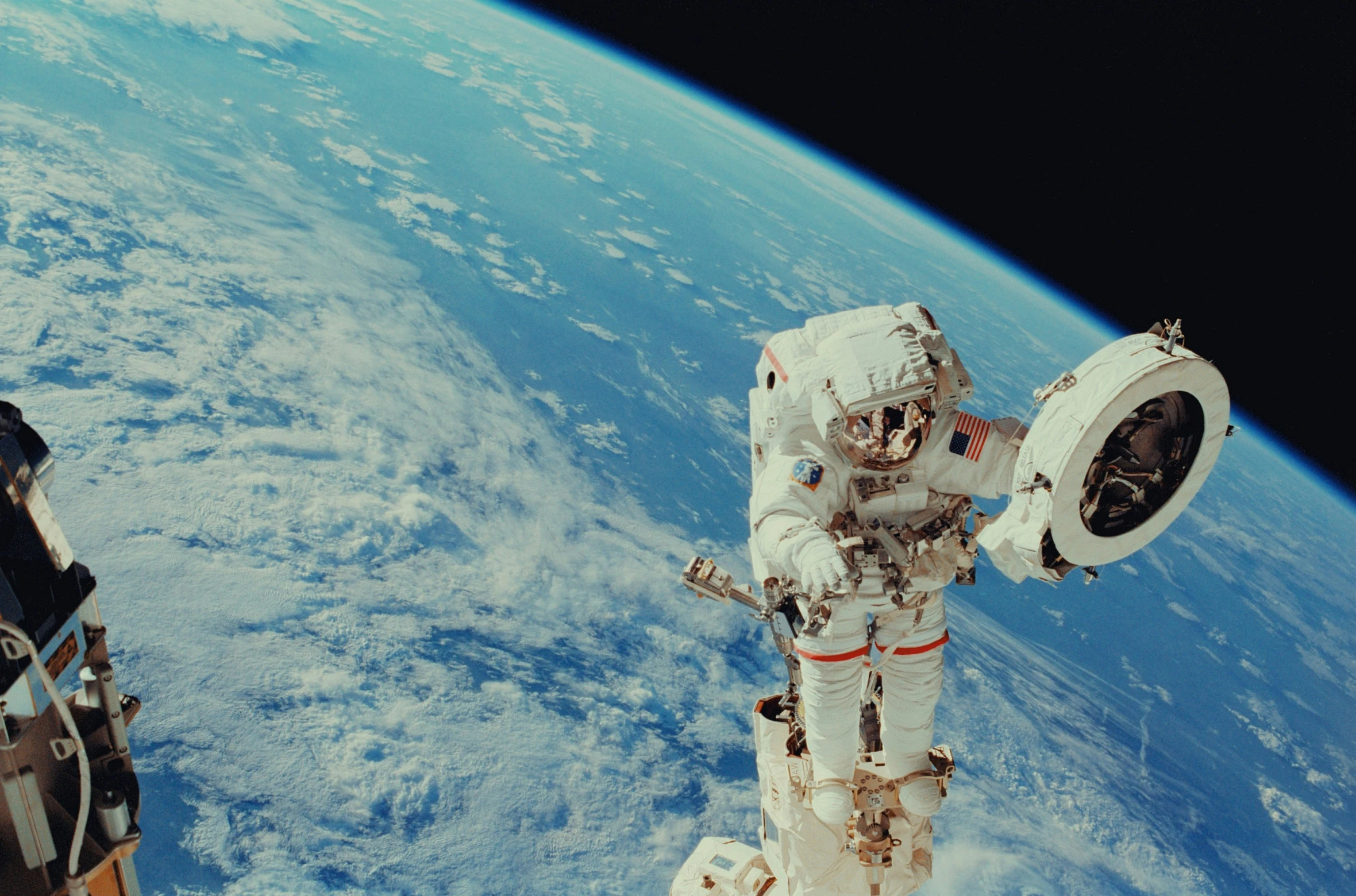 an astronaut floating in the blue space above earth