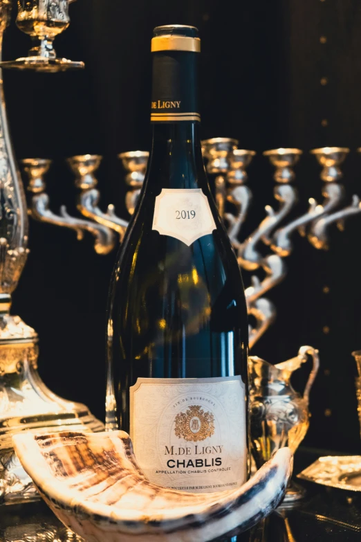 bottle of wine sitting on table next to silver wine glasses