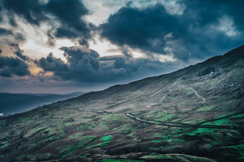 an overcast sky in the middle of mountains and winding roads