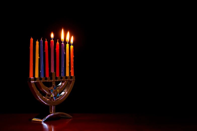 a lit menorah on a table with candles inside