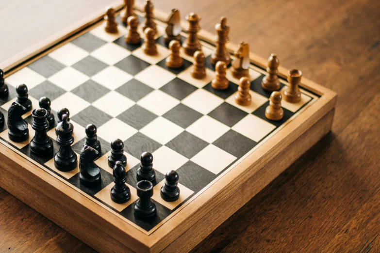 a chess set with a wooden board and black pieces