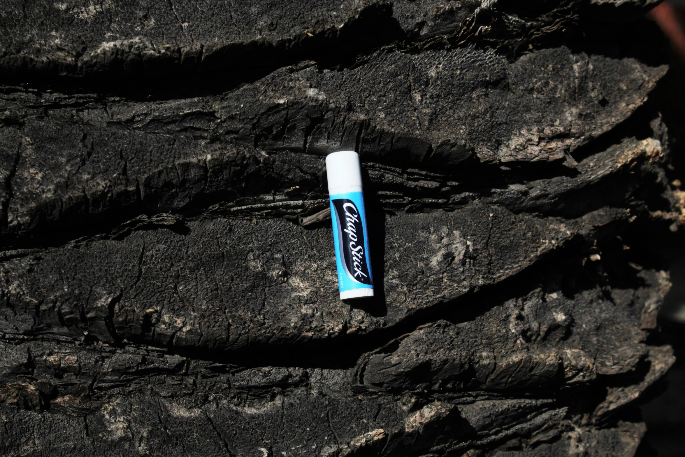a roll of toothpaste sitting on a rock