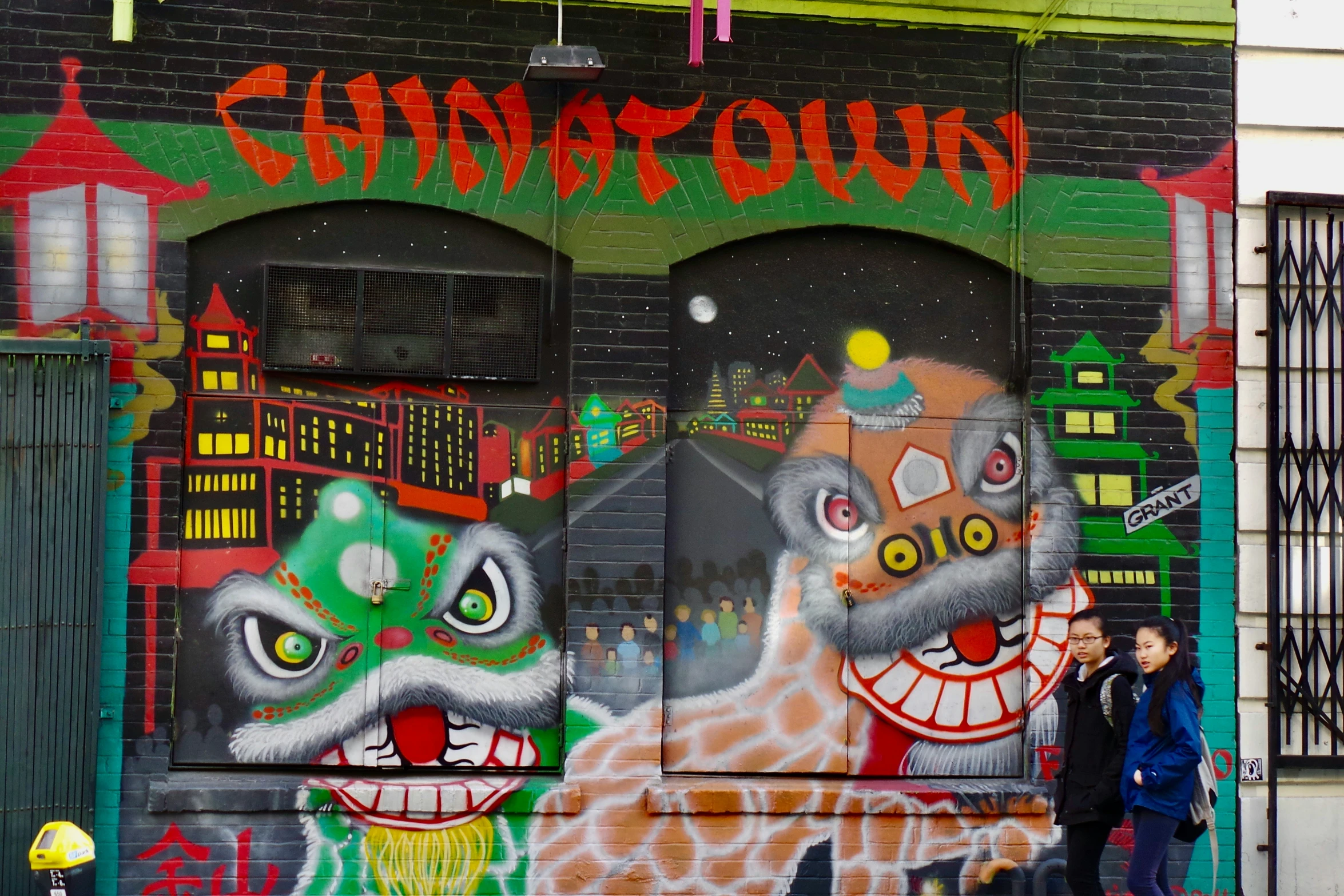 a person walking past a graffiti covered building