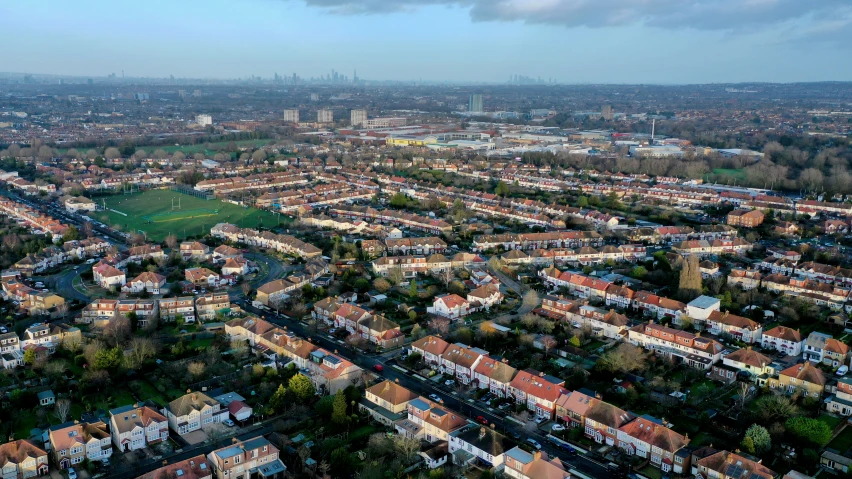 an overhead view of a city with brown roofed houses and parking lots