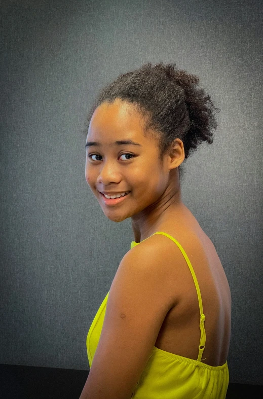 a girl posing for a po in a yellow dress