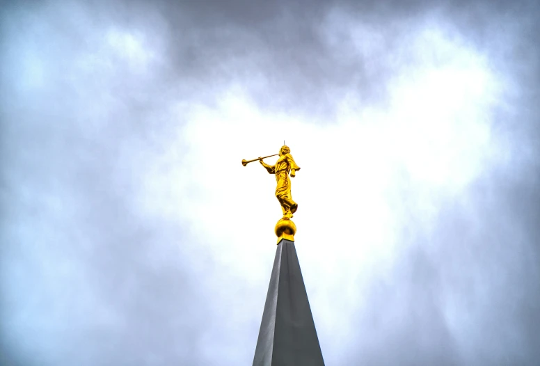 the statue is standing on the top of the building