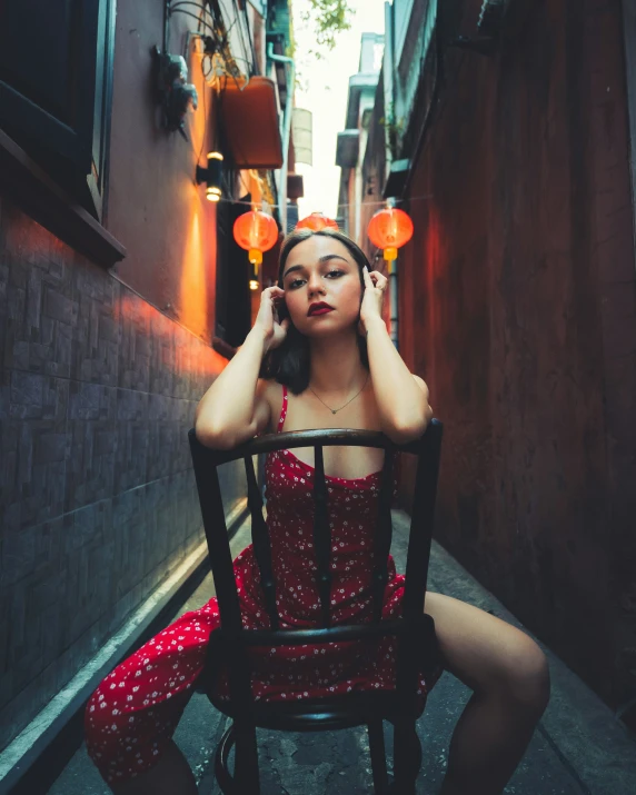 a woman sits in a chair talking on a cellphone