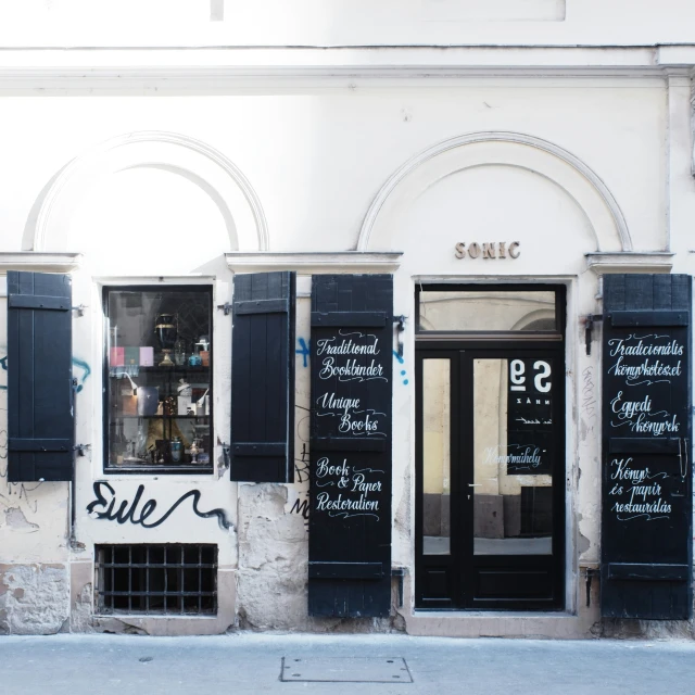 this store has black shutters and sign on the windows