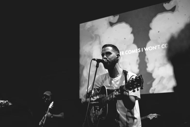 a black and white po of a man with a guitar