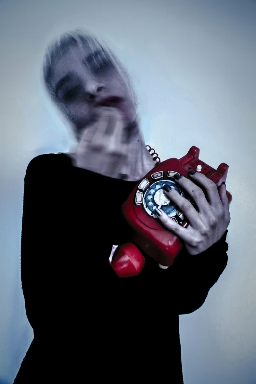 a woman is holding a red toy and phone