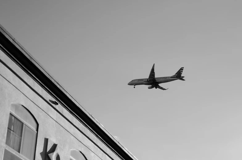 a large jet flying over an old building