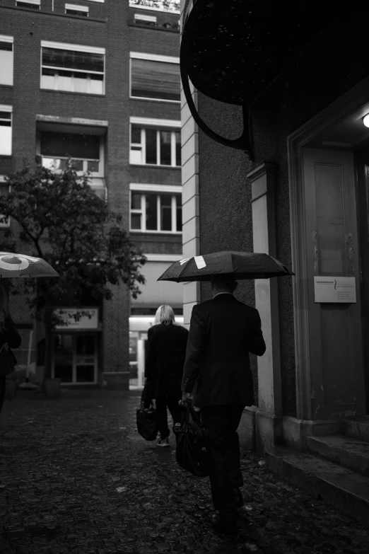 black and white po of people walking with an umbrella