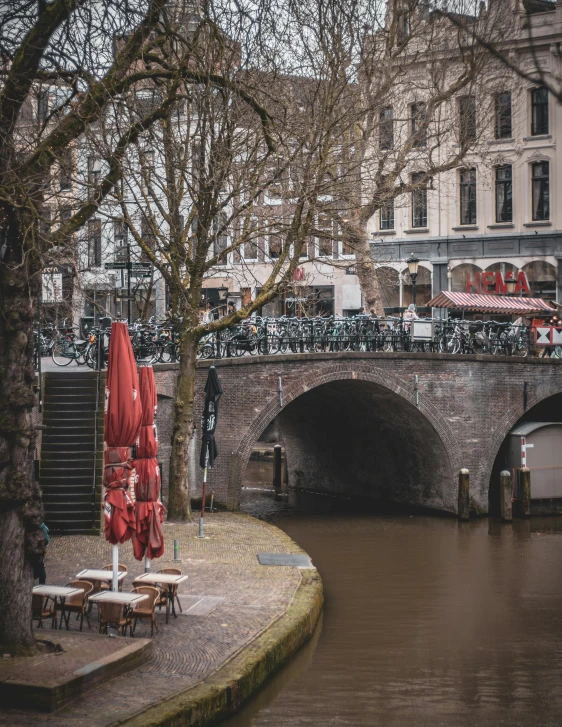 two red umbrellas are next to a bridge and water