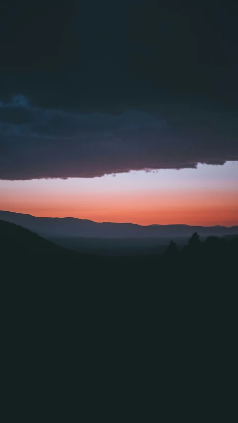 there are many trees on the hill top at sunset