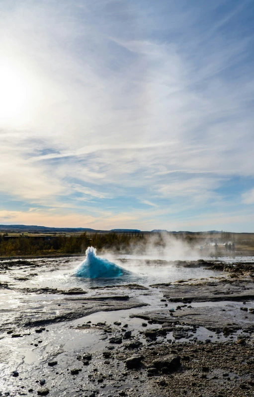 a blue rock with steam billowing out the ground