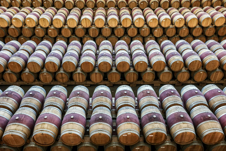 many barrels are stacked with different colors and sizes