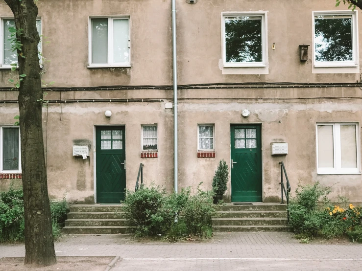 a house with green doors on the side of it