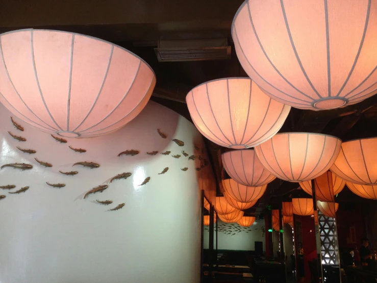 several lamps in a restaurant with mosquito on them