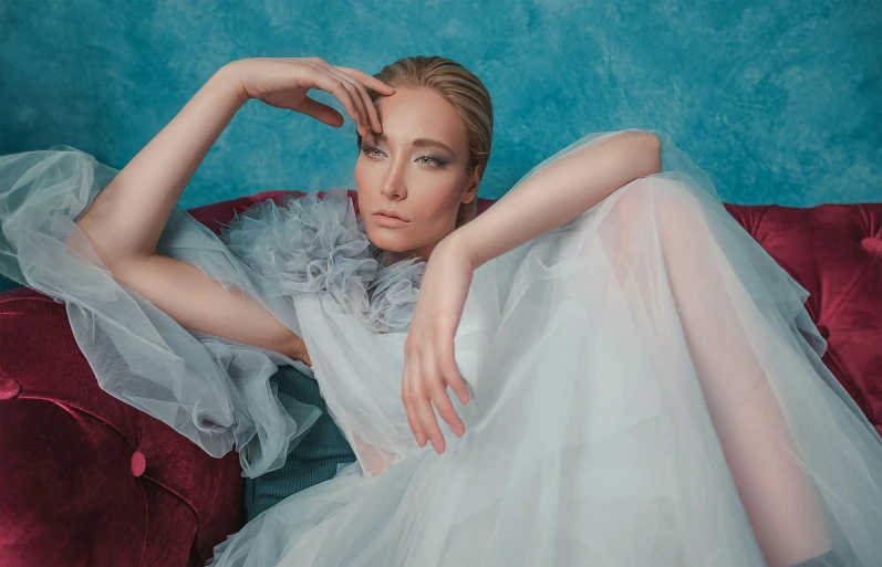 a woman in a dress lying on a red couch