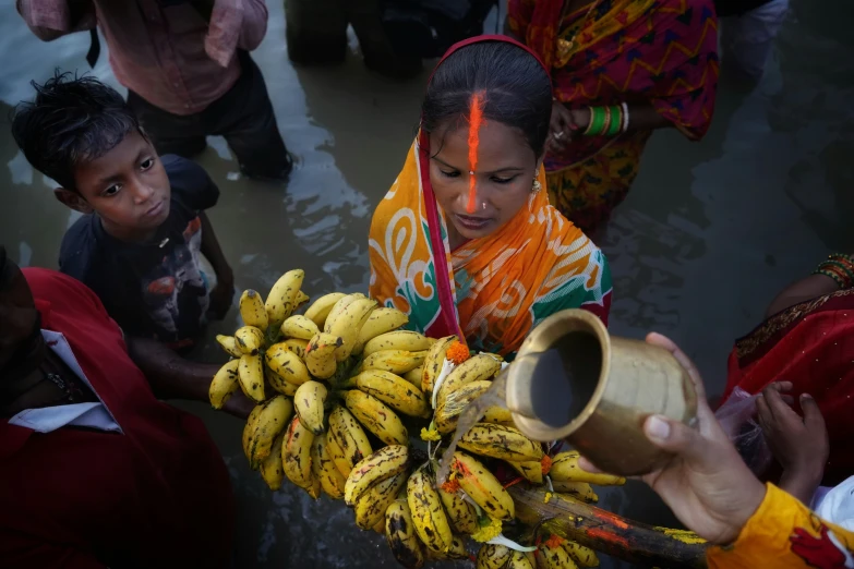 a woman holding a large amount of bananas