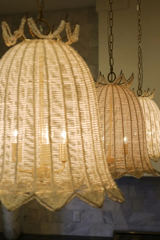 several lamps that have wicker patterns hanging from it