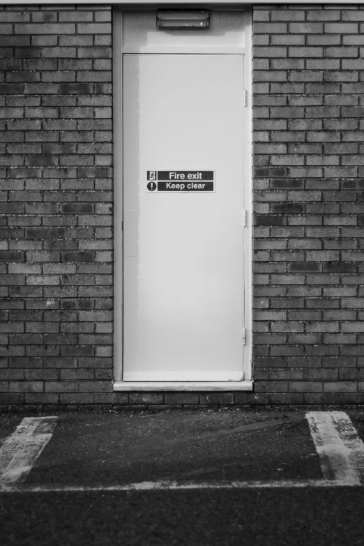 a building with a white door, black and white po of the entrance
