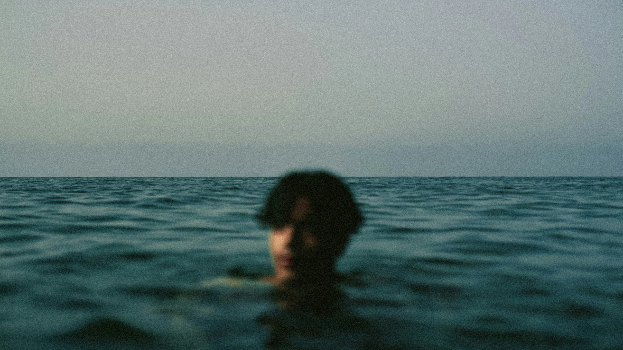 person is in the middle of water looking at the camera