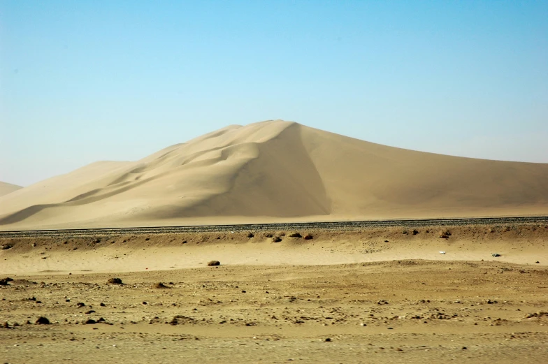 a large dune sitting in the middle of the desert