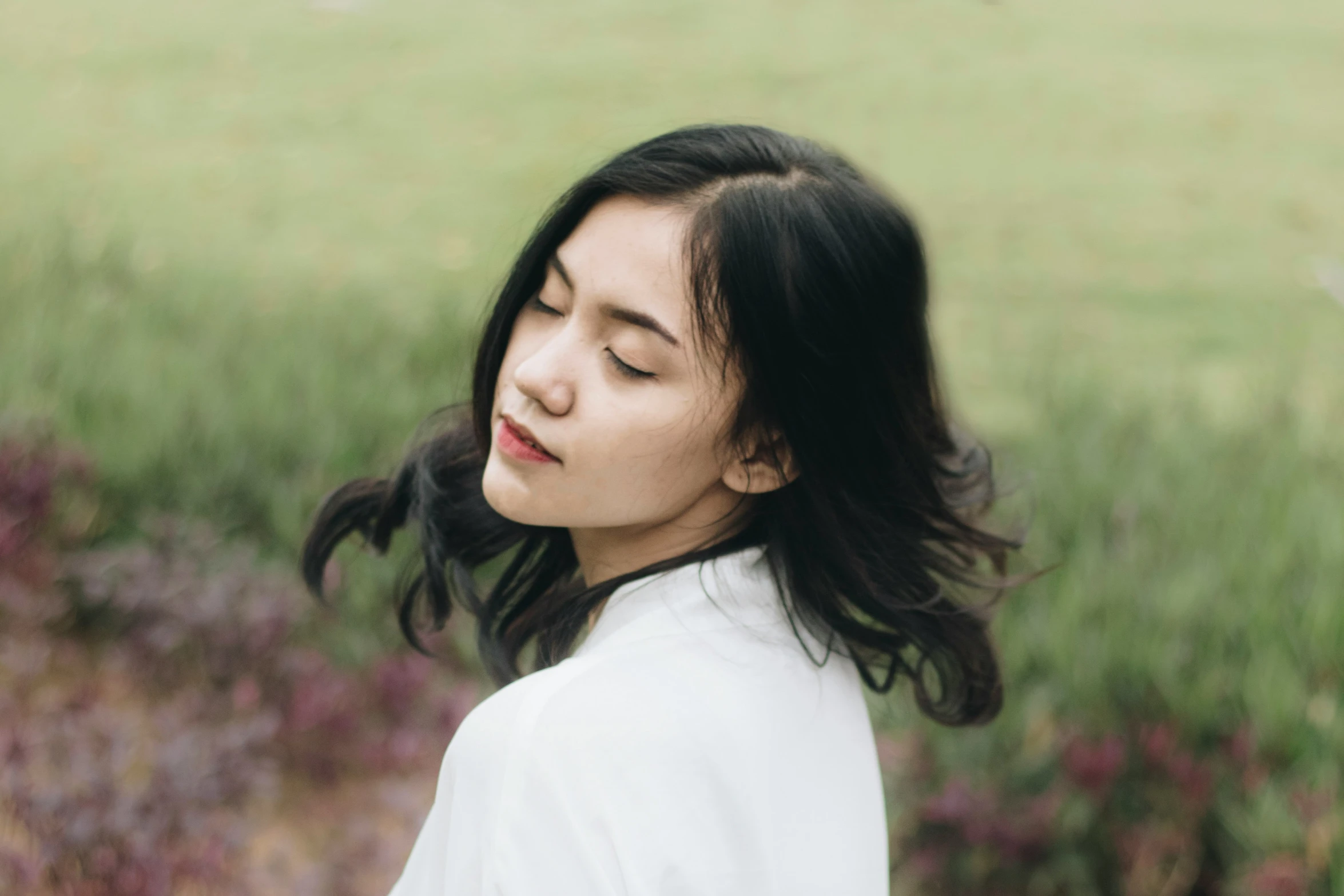 a woman wearing a white shirt in the grass