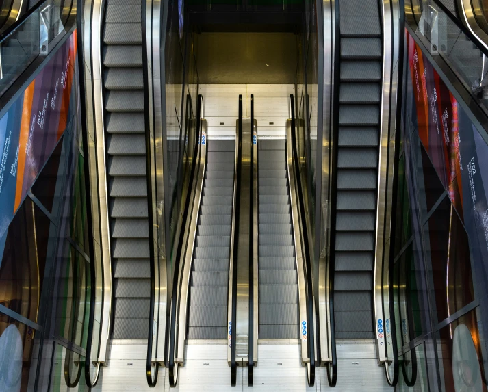 an escalator in front of two staircases and an elevator
