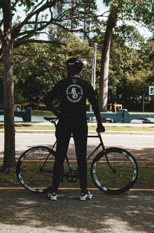 a man with a helmet and some bike standing by some trees