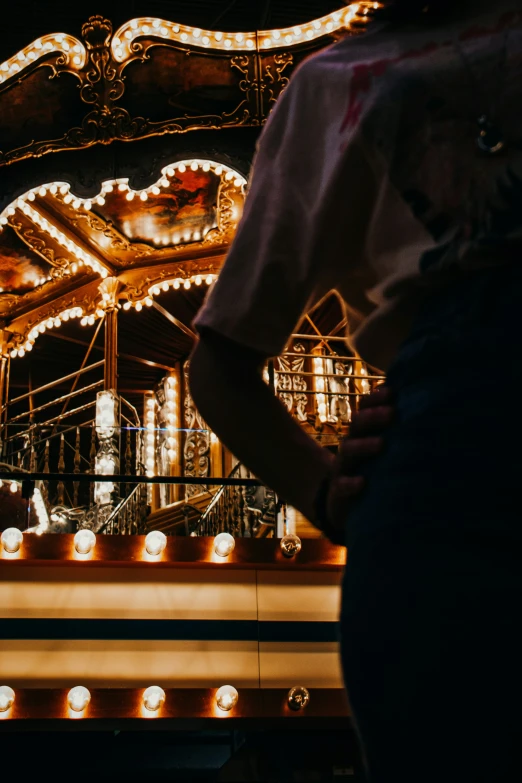 people look at an illuminated carnival ride