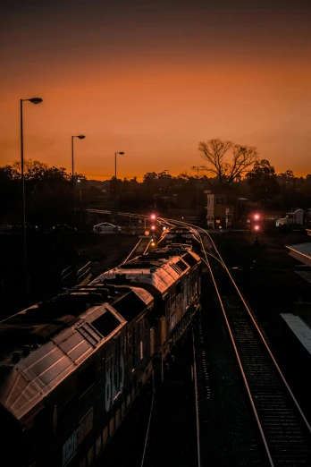 an image of train coming down the tracks at sunset