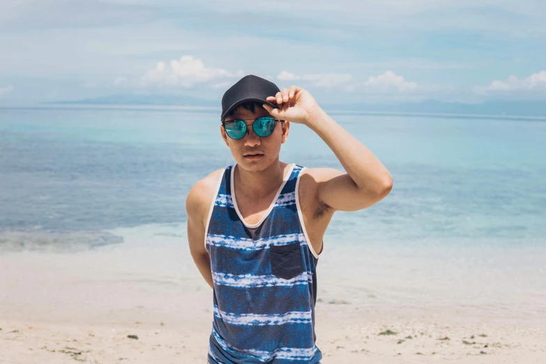 a man in a blue and white tank top wearing glasses