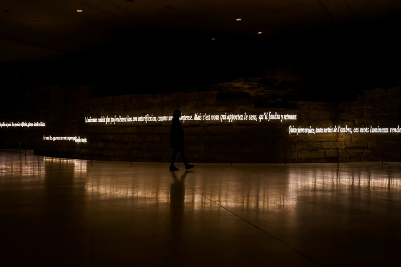 a man is walking on a darkened floor