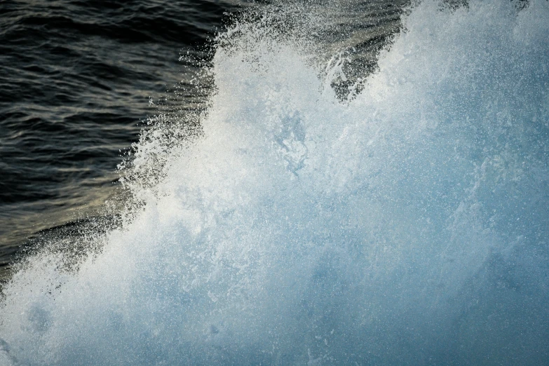 the spray is coming off of a wave