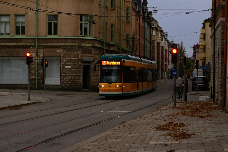 a yellow trolly is going down a dark street