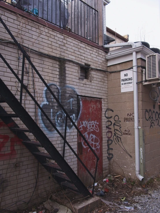 the side of a building with graffiti on it and a metal handrail