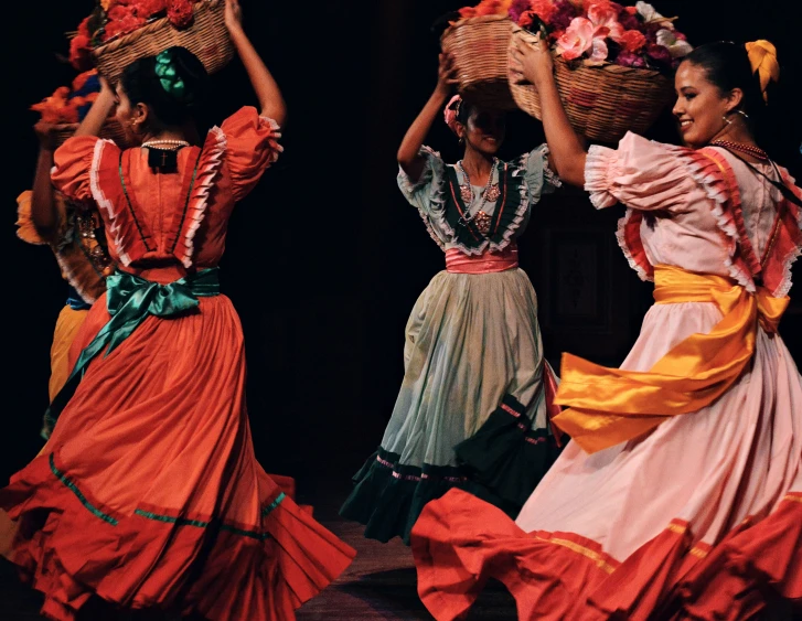 a group of women dance around a basket of flowers