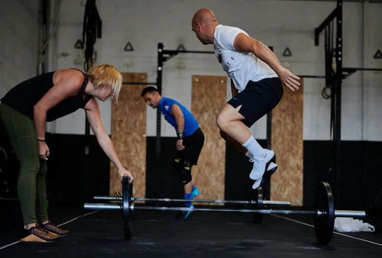 two women lifting one another in a gym